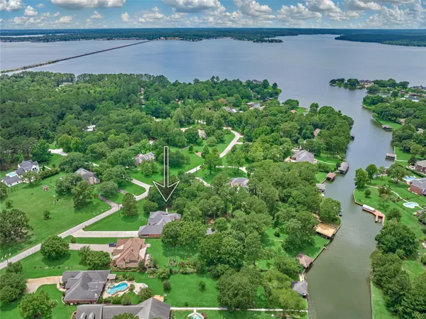 an aerial view of a house with a yard and lake view