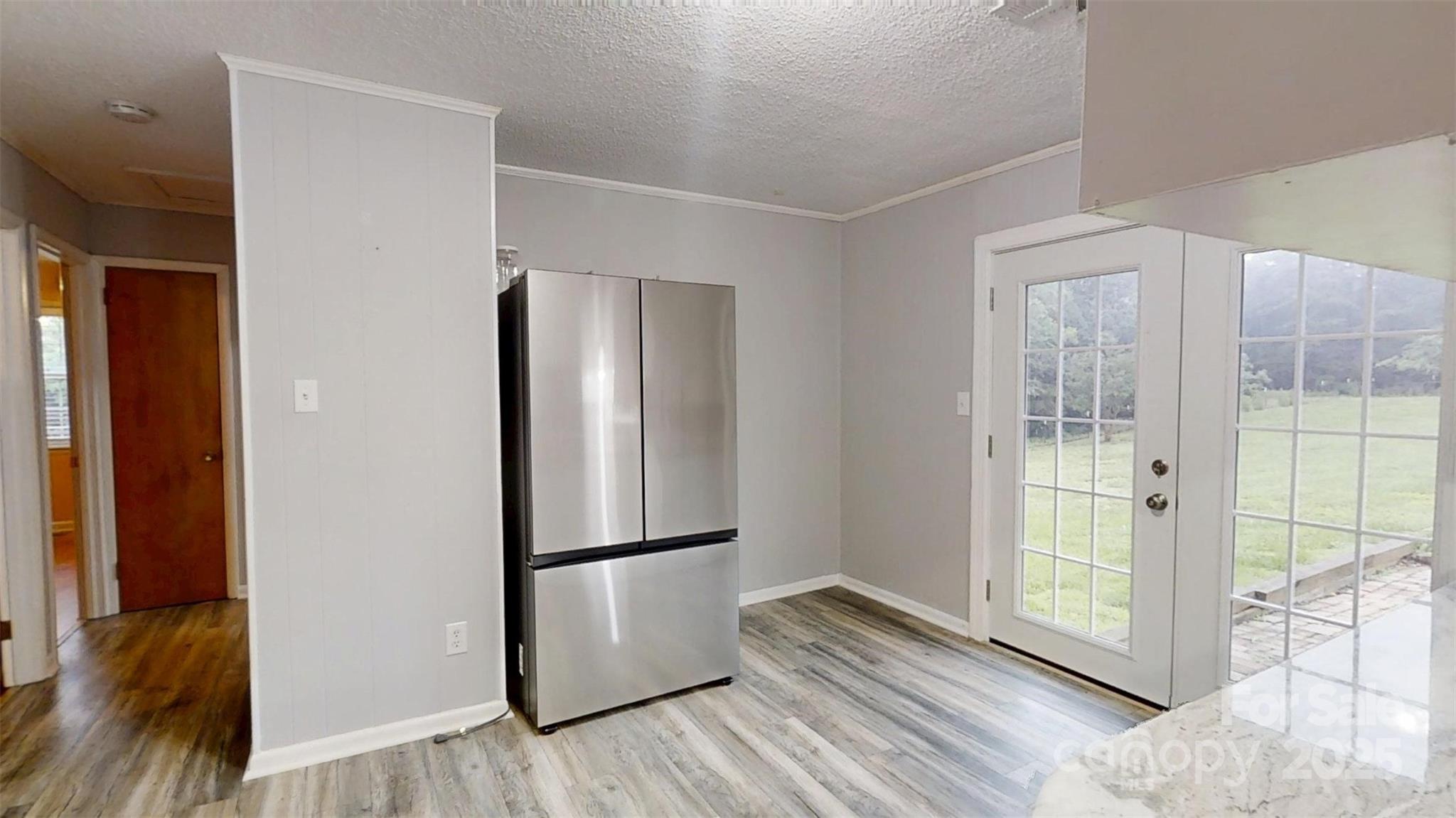 3151 Lynn Mountain Road Vale, NC 28168 - Photo 13 of 38 a view of a refrigerator in kitchen and an empty room with wooden floor