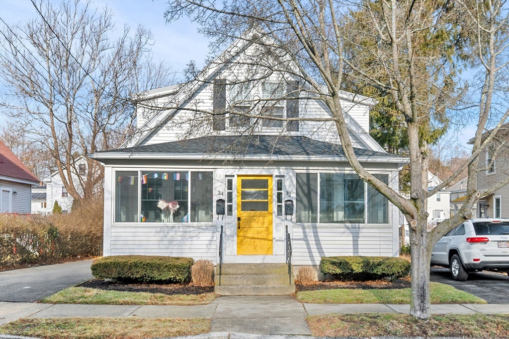 a front view of a house with a yard and trees