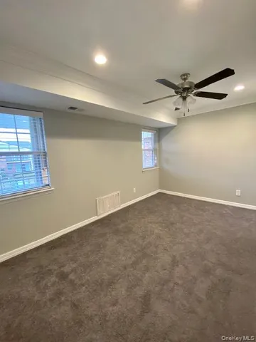 an empty room with windows and fan