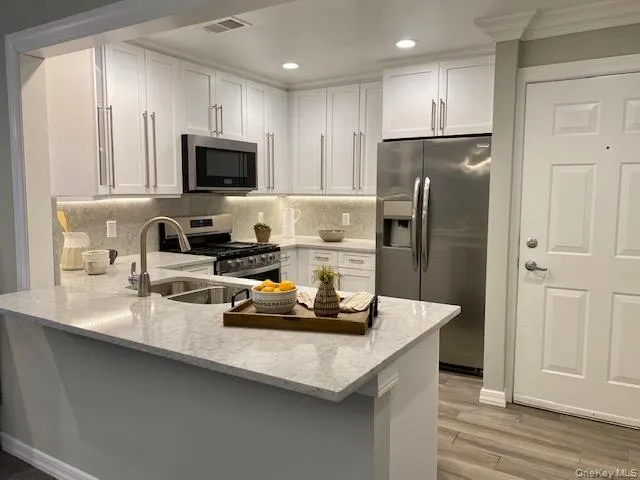 a kitchen with a refrigerator a stove a sink and a microwave