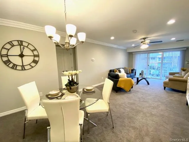 a living room with furniture a chandelier and a mirror