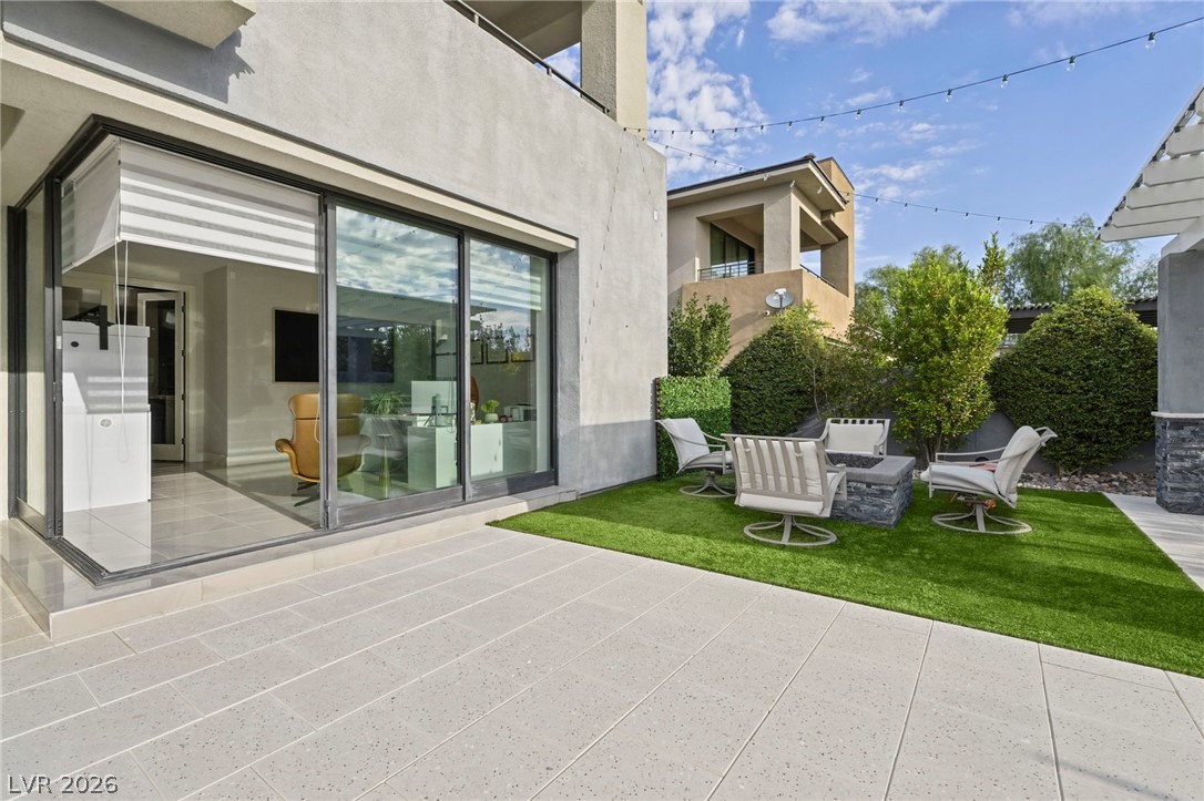 4208 Lapis Ridge Court Las Vegas, NV 89135 - Photo 49 of 61 Sliding glass doors connect the interior living space to a modern stone patio.