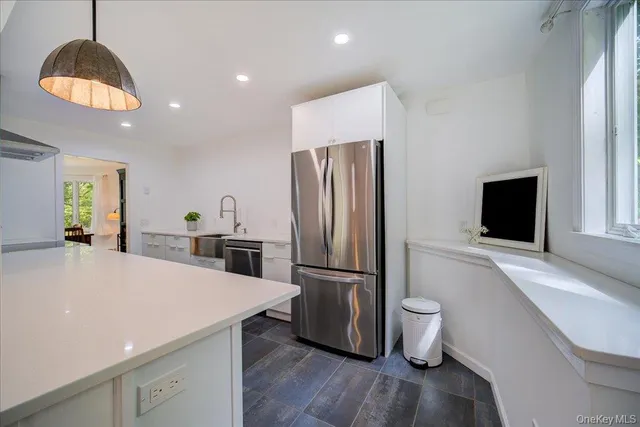a kitchen with granite countertop a sink and white cabinets
