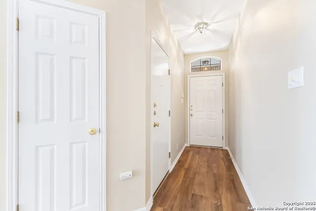 a view of a hallway with wooden floor