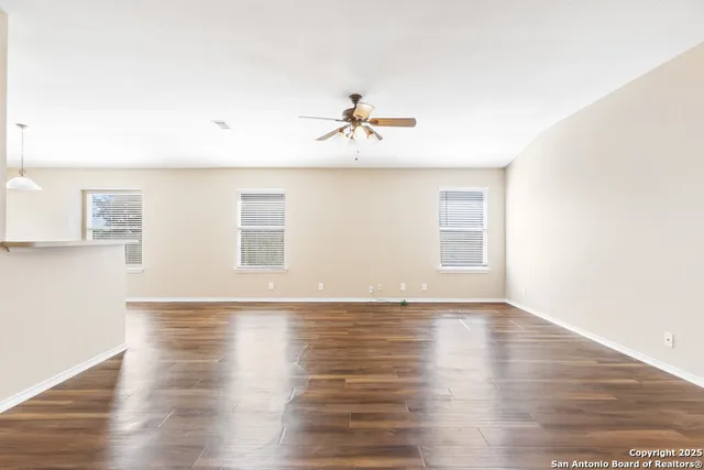 a view of a room with wooden floor and a ceiling fan