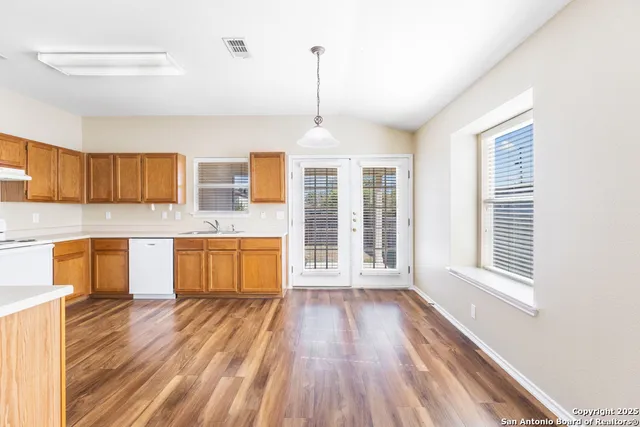 a kitchen with stainless steel appliances granite countertop a stove a sink and a wooden floors