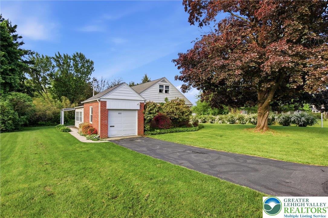 This charming residence features a well-maintained lawn and a convenient attached garage.