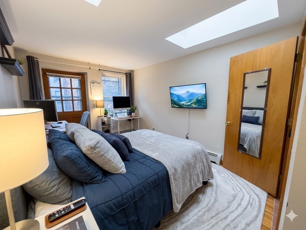 22 Battery Street, Unit 1R Boston, MA 02109 - Photo 5 of 8 a bed room with a bed and a couch