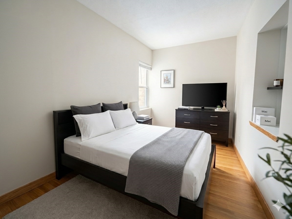 22 Battery Street, Unit 1R Boston, MA 02109 - Photo 6 of 8 a spacious bedroom with a bed and a flat screen tv