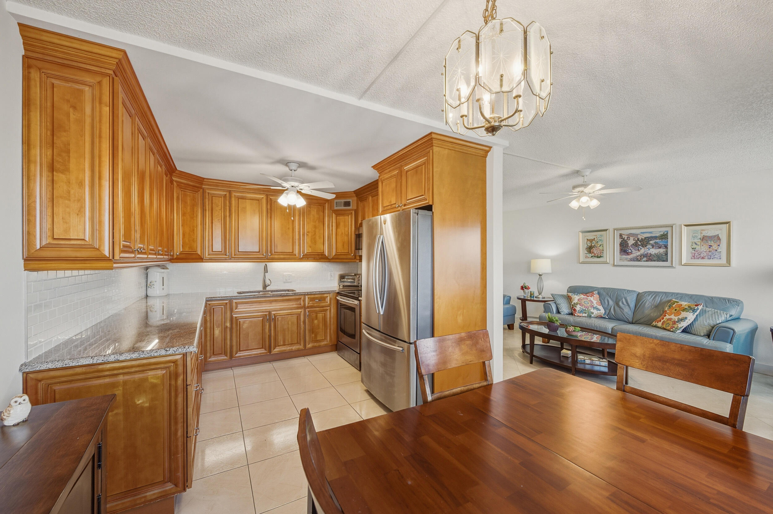 3063 Yarmouth C Boca Raton, FL 33434 - Photo 18 of 40 a living room with furniture and a chandelier