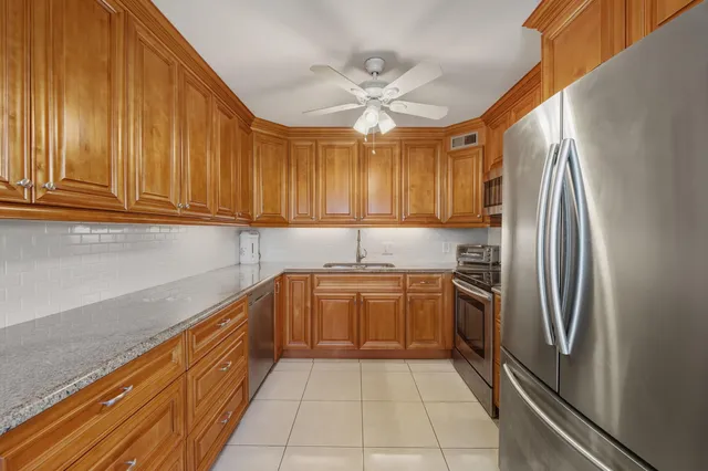 a kitchen with stainless steel appliances granite countertop a sink dishwasher stove and refrigerator