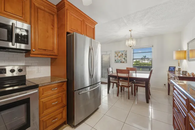 a kitchen with granite countertop a refrigerator stove top oven and sink