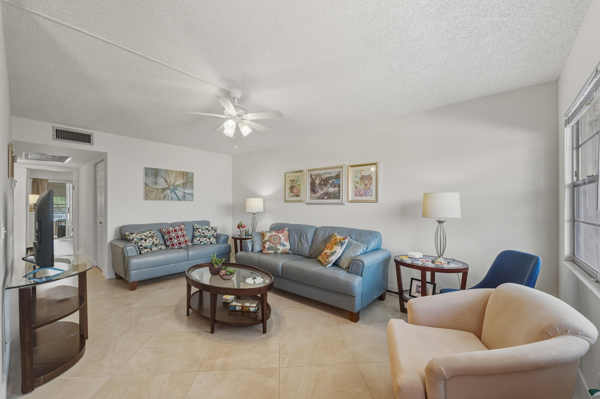 3063 Yarmouth C Boca Raton, FL 33434 - Photo 23 of 40 a living room with furniture a couch and a chandelier