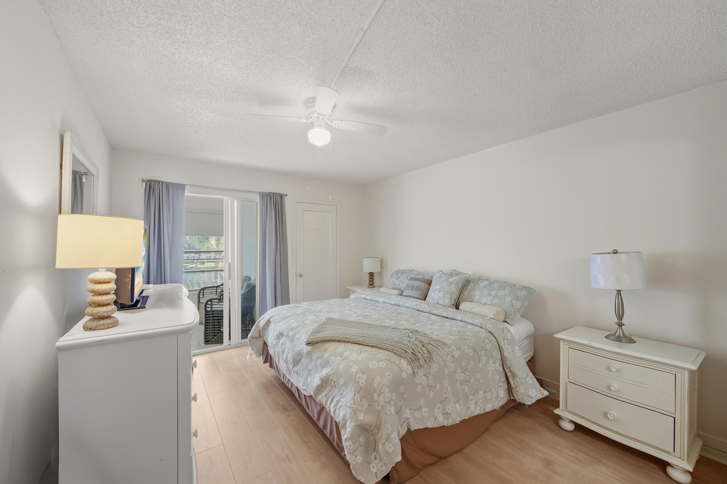 3063 Yarmouth C Boca Raton, FL 33434 - Photo 34 of 40 a bed room with a bed and a lamp