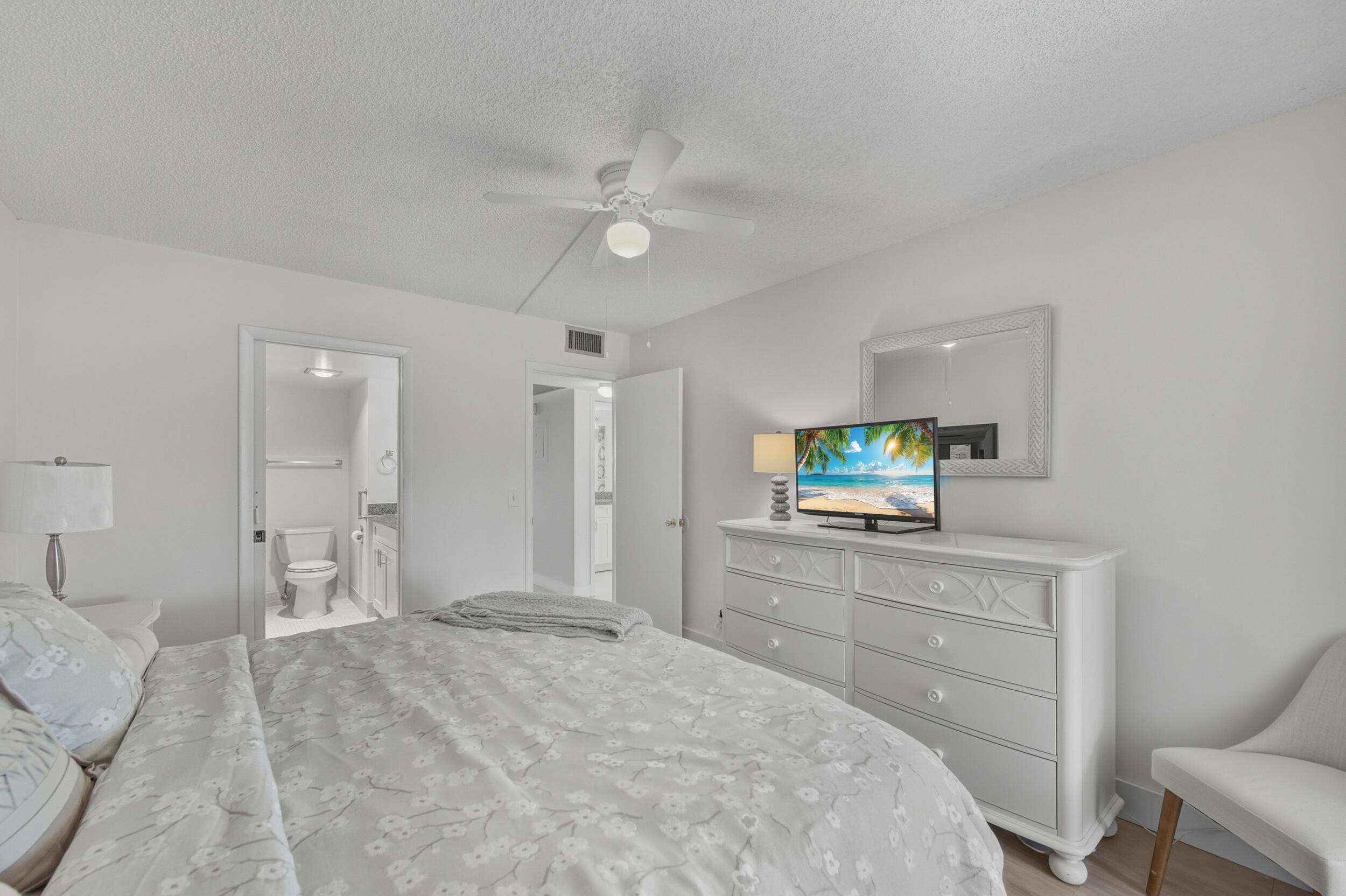 3063 Yarmouth C Boca Raton, FL 33434 - Photo 36 of 40 a bedroom with a bed and a flat screen tv