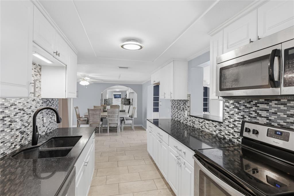 545 Bluebell Road Venice, FL 34293 - Photo 14 of 36 a kitchen with stainless steel appliances granite countertop a sink stove and cabinets