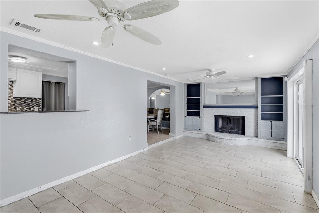 545 Bluebell Road Venice, FL 34293 - Photo 16 of 36 an empty room with fireplace and fan
