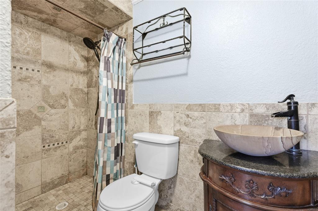 545 Bluebell Road Venice, FL 34293 - Photo 23 of 36 a bathroom with a granite countertop toilet a sink and a shower