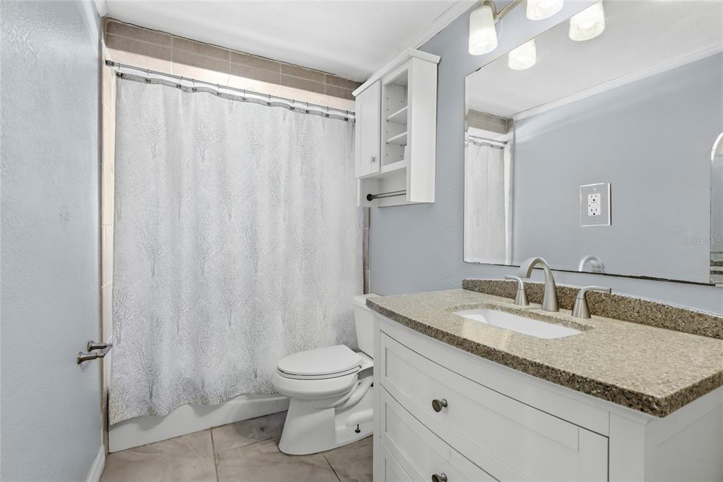 545 Bluebell Road Venice, FL 34293 - Photo 26 of 36 a bathroom with a granite countertop sink and a mirror