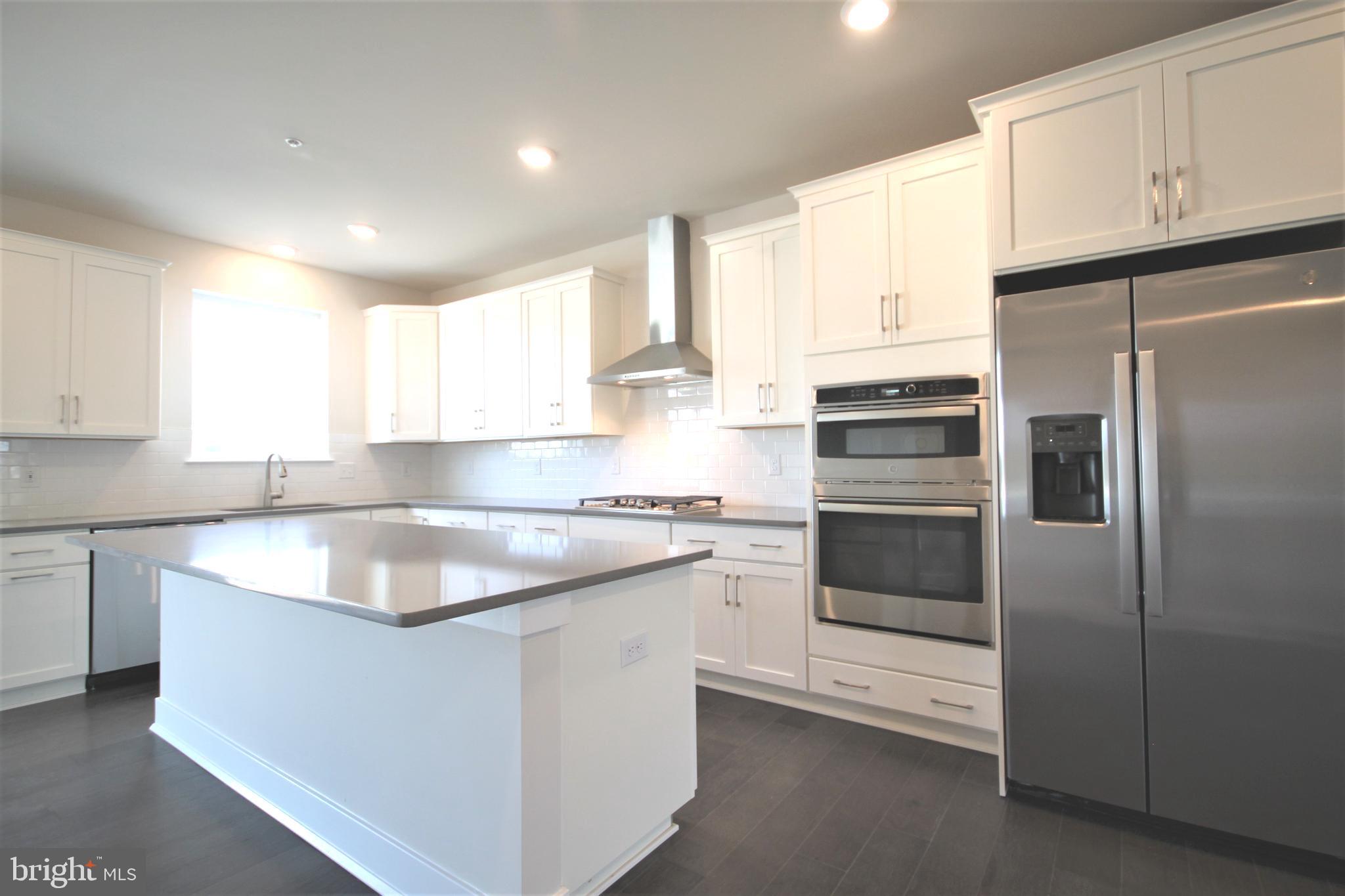 4856 Stump Road Pipersville, PA 18947 - Photo 11 of 35 a kitchen with stainless steel appliances granite countertop a sink a stove a refrigerator with white cabinets