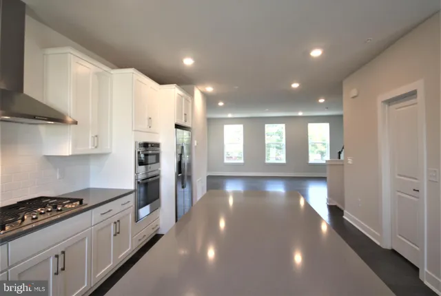 a view of kitchen with stove and refrigerator
