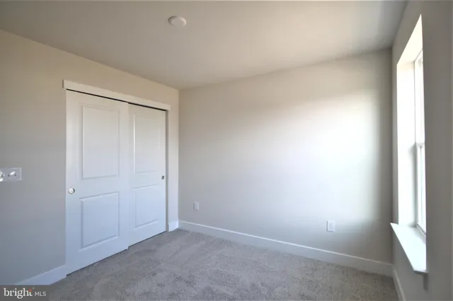 an empty room with windows and closet