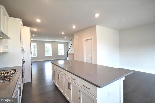 a kitchen with stainless steel appliances granite countertop a sink a stove and a refrigerator