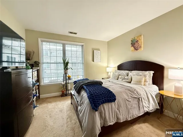 a bedroom with a bed next to a window