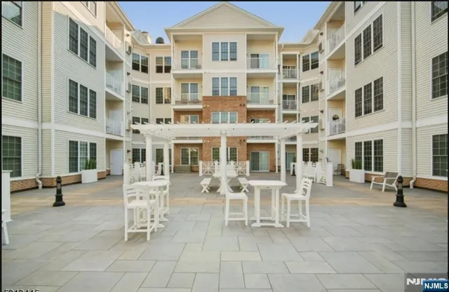 a view of a brick building with many windows table and chairs