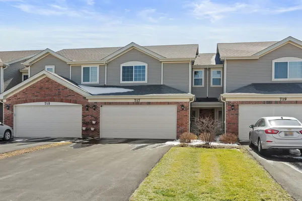 a front view of a house with a yard and a garage