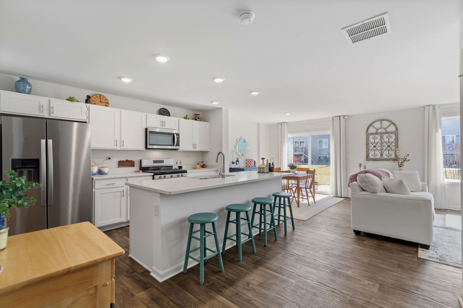 717 Wellington Lane Cary, IL 60013 - Photo 3 of 28 a kitchen with a refrigerator a stove a sink dishwasher a oven with a dining table and chairs
