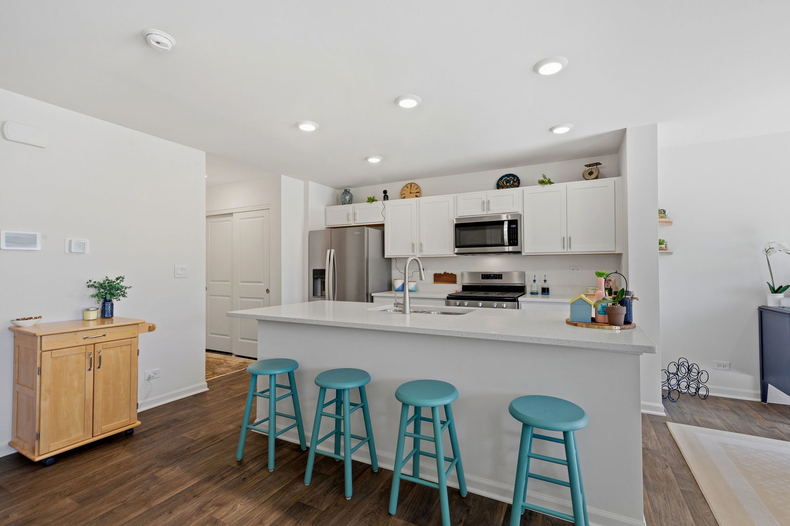 717 Wellington Lane Cary, IL 60013 - Photo 4 of 28 a kitchen with stainless steel appliances a white table chairs and a refrigerator
