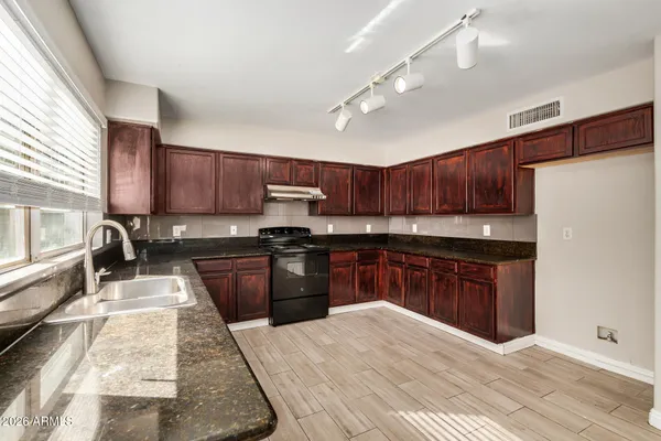a kitchen with granite countertop wooden cabinets a stove top oven and granite counter tops