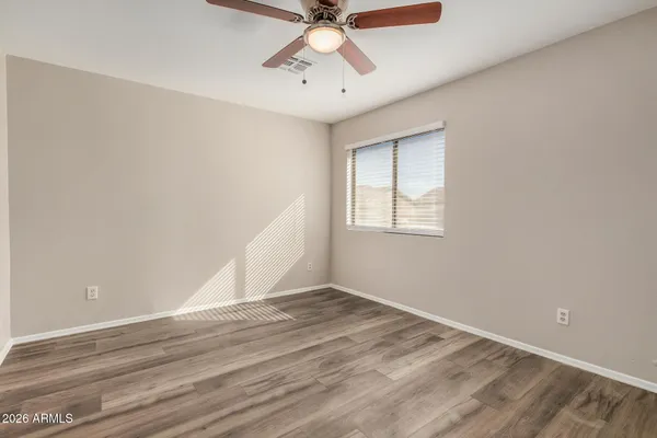 a view of an empty room with window and wooden floor