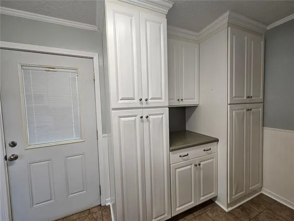 a kitchen with white cabinets and white appliances