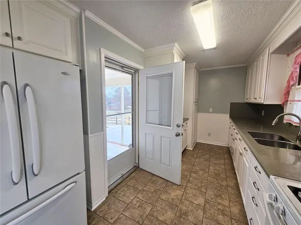 a kitchen with granite countertop a refrigerator and a sink