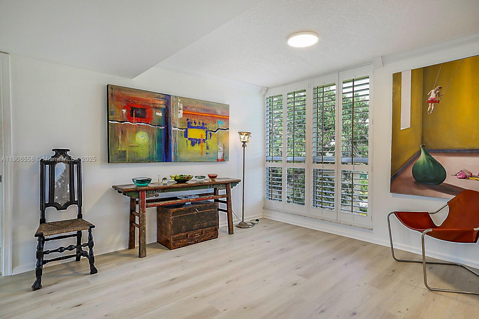 5390 Woodland Lakes Drive, Unit 301 Palm Beach Gardens, FL 33418 - Photo 12 of 34 a living room with furniture a flat screen tv and a window