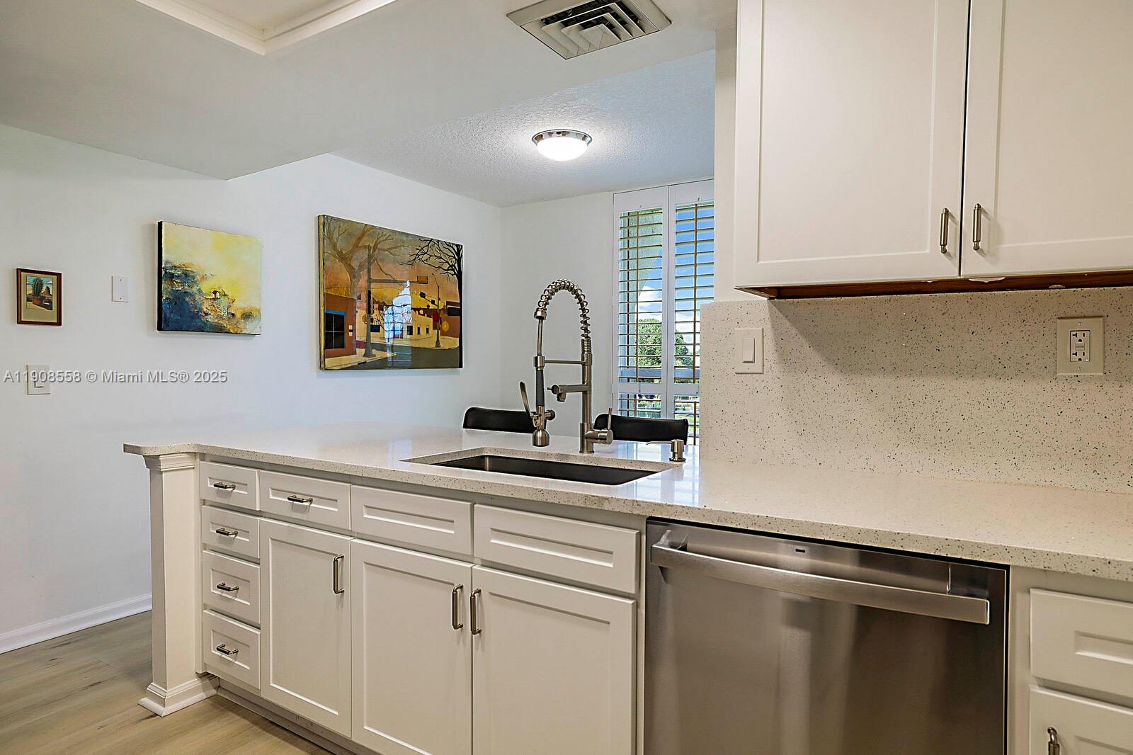 5390 Woodland Lakes Drive, Unit 301 Palm Beach Gardens, FL 33418 - Photo 15 of 34 a kitchen with stainless steel appliances white cabinets and a sink
