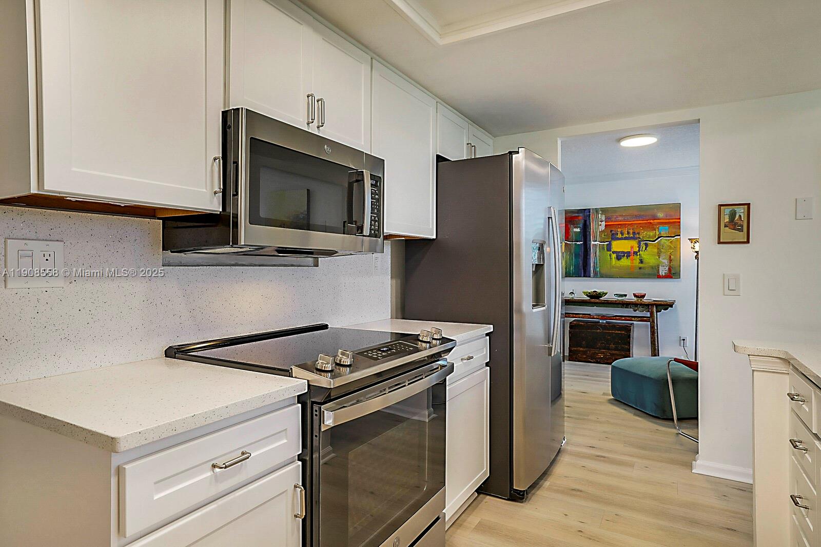 5390 Woodland Lakes Drive, Unit 301 Palm Beach Gardens, FL 33418 - Photo 16 of 34 a kitchen with stainless steel appliances a stove microwave and refrigerator