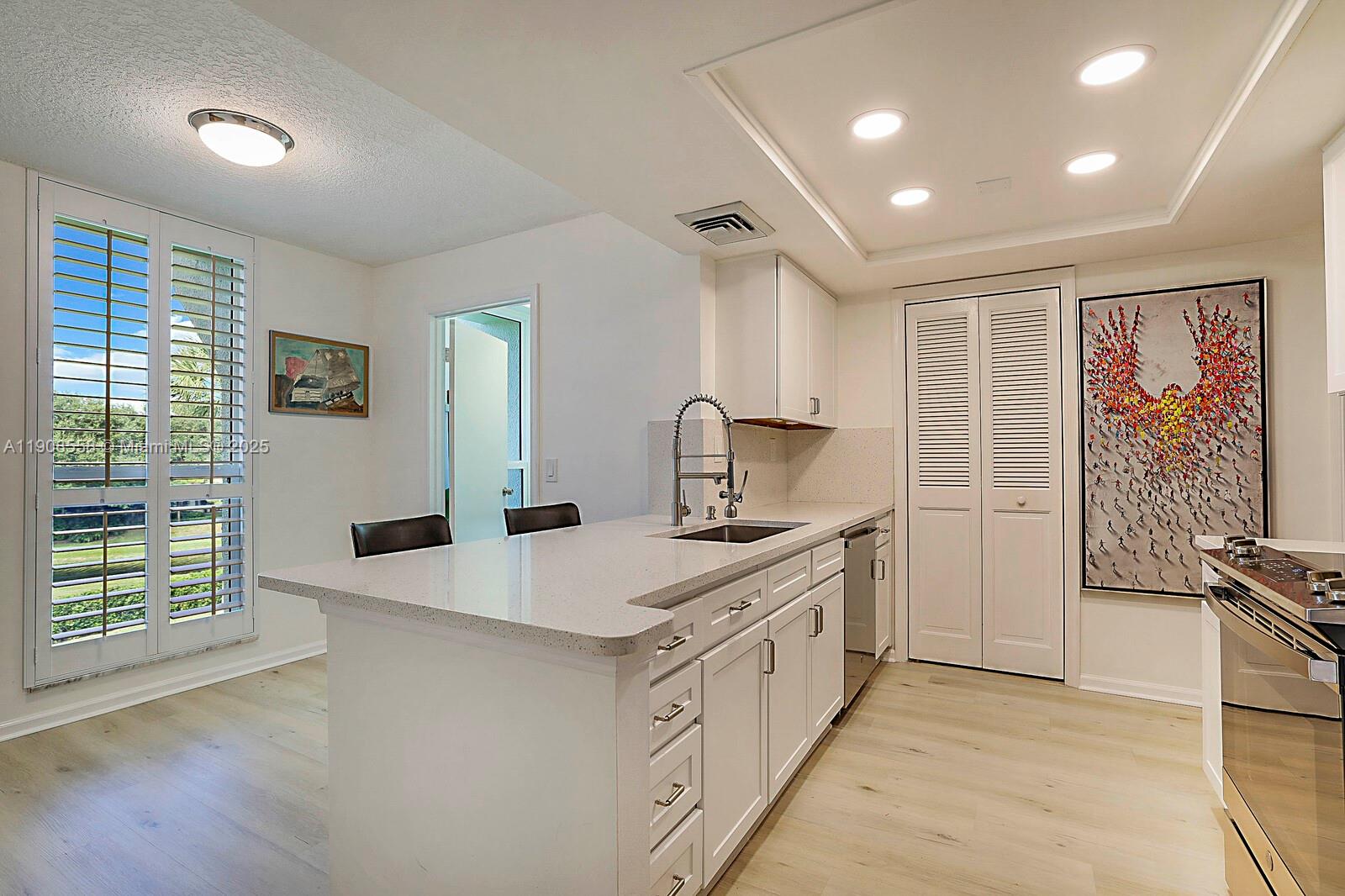 5390 Woodland Lakes Drive, Unit 301 Palm Beach Gardens, FL 33418 - Photo 18 of 34 a kitchen with stainless steel appliances granite countertop a sink stove and refrigerator