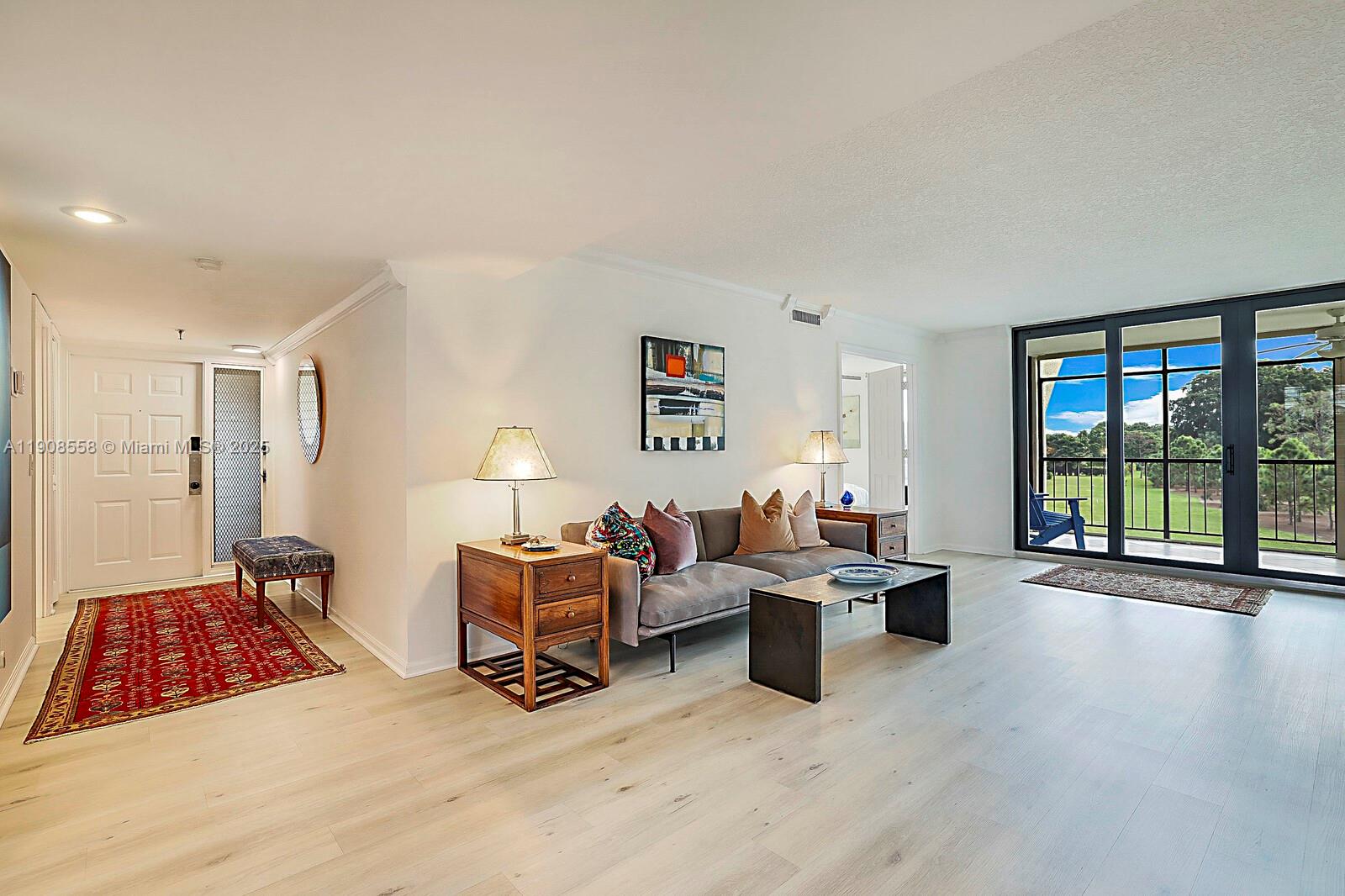 5390 Woodland Lakes Drive, Unit 301 Palm Beach Gardens, FL 33418 - Photo 2 of 34 a bedroom with furniture and a large window