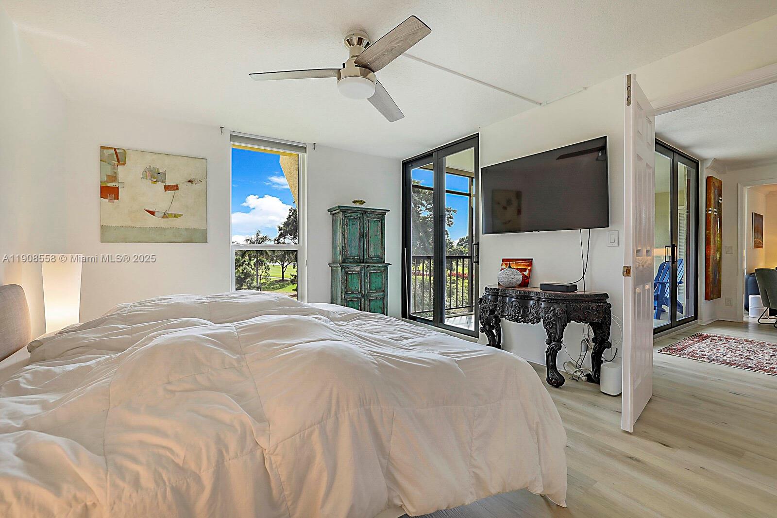 5390 Woodland Lakes Drive, Unit 301 Palm Beach Gardens, FL 33418 - Photo 21 of 34 a bed room with a bed mirror and a flat tv screen