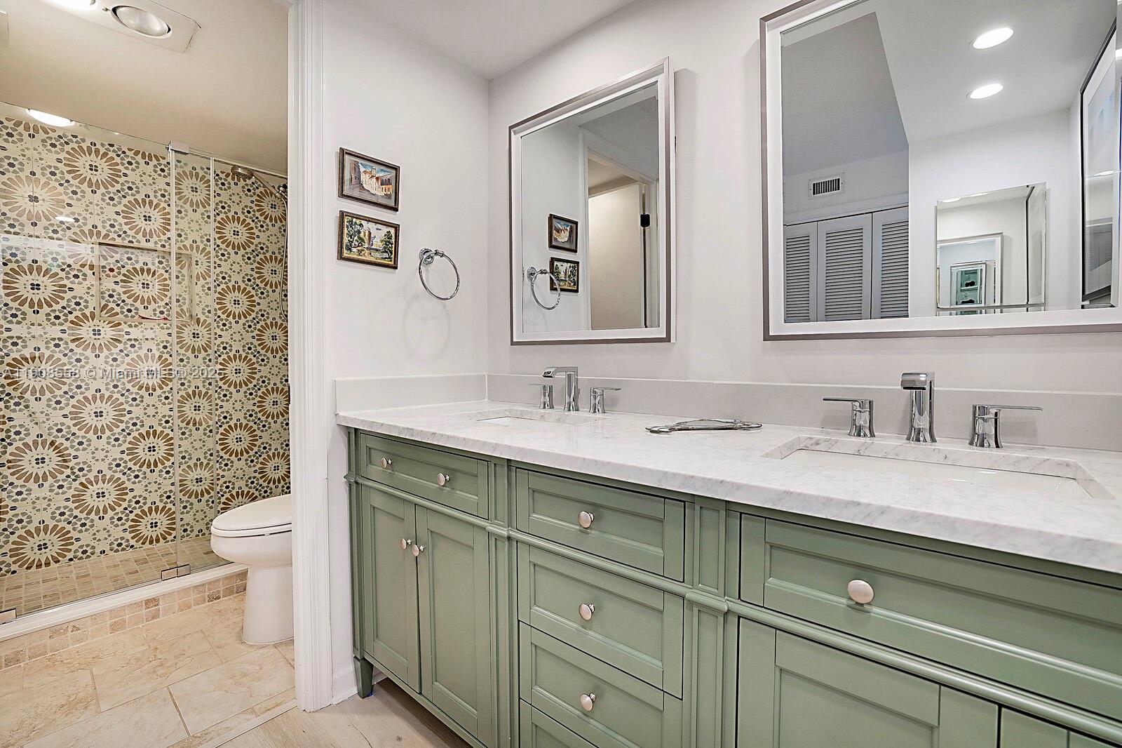 5390 Woodland Lakes Drive, Unit 301 Palm Beach Gardens, FL 33418 - Photo 23 of 34 a bathroom with a granite countertop toilet sink and mirror