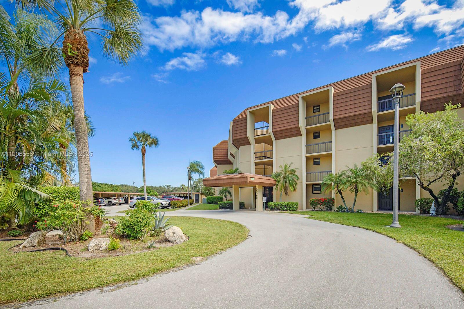 5390 Woodland Lakes Drive, Unit 301 Palm Beach Gardens, FL 33418 - Photo 32 of 34 a front view of a building with garden