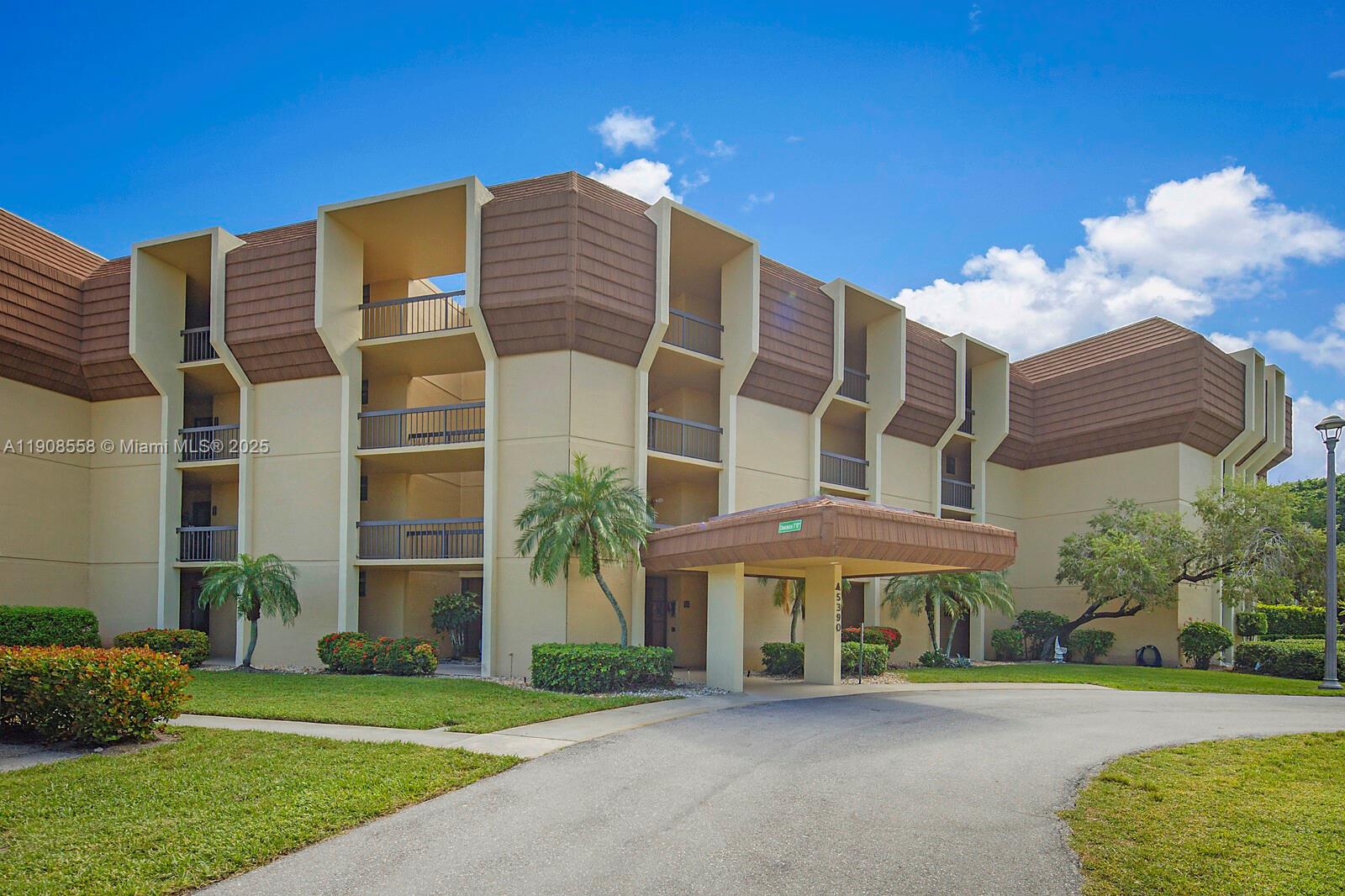 5390 Woodland Lakes Drive, Unit 301 Palm Beach Gardens, FL 33418 - Photo 33 of 34 a front view of a building