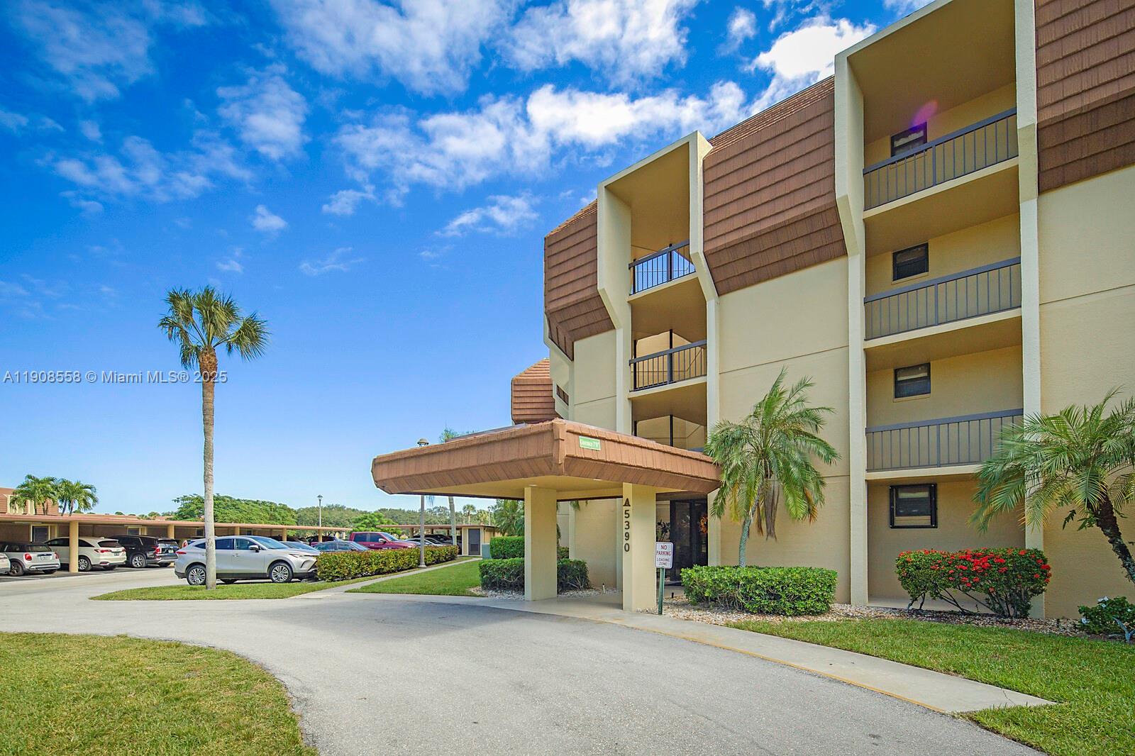 5390 Woodland Lakes Drive, Unit 301 Palm Beach Gardens, FL 33418 - Photo 34 of 34 a street view with tall buildings and a yard