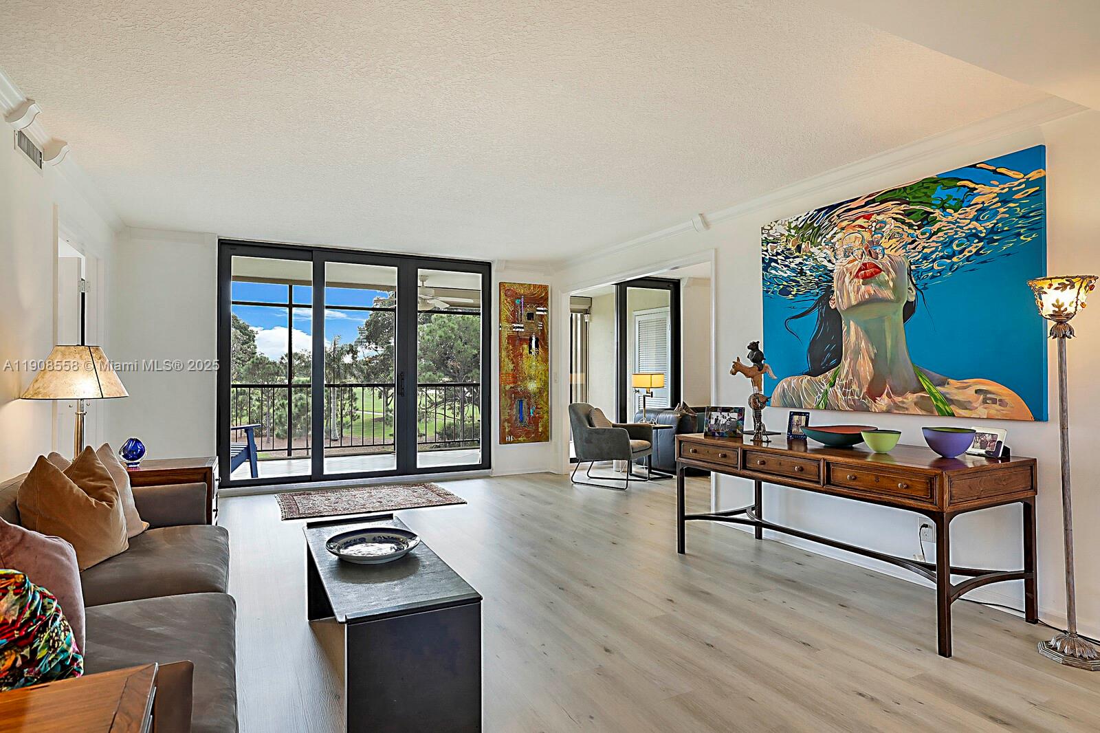 5390 Woodland Lakes Drive, Unit 301 Palm Beach Gardens, FL 33418 - Photo 4 of 34 a living room with furniture and a large window