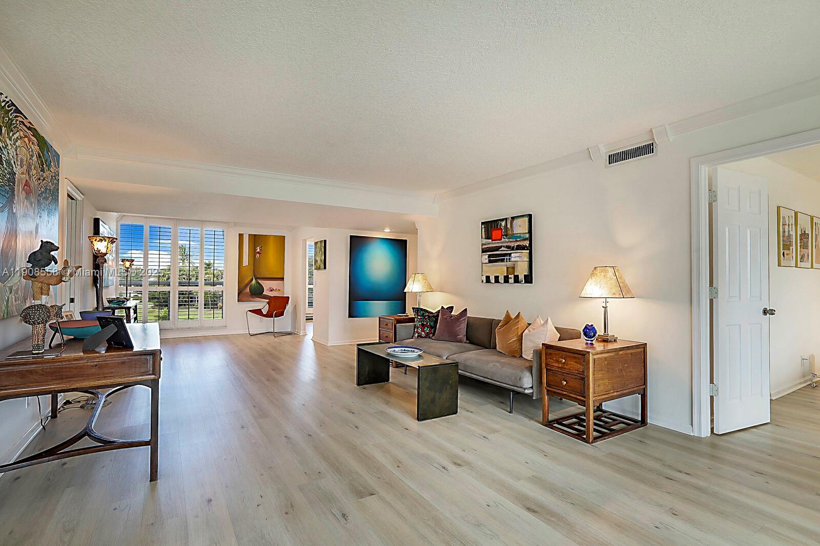 5390 Woodland Lakes Drive, Unit 301 Palm Beach Gardens, FL 33418 - Photo 5 of 34 a living room with furniture and a wooden floor