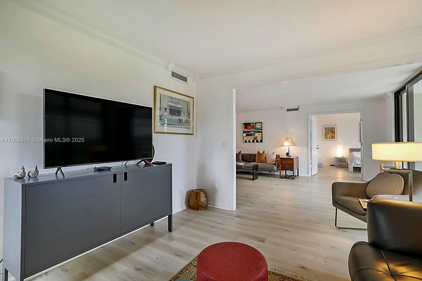 5390 Woodland Lakes Drive, Unit 301 Palm Beach Gardens, FL 33418 - Photo 10 of 34 a living room with furniture and a flat screen tv